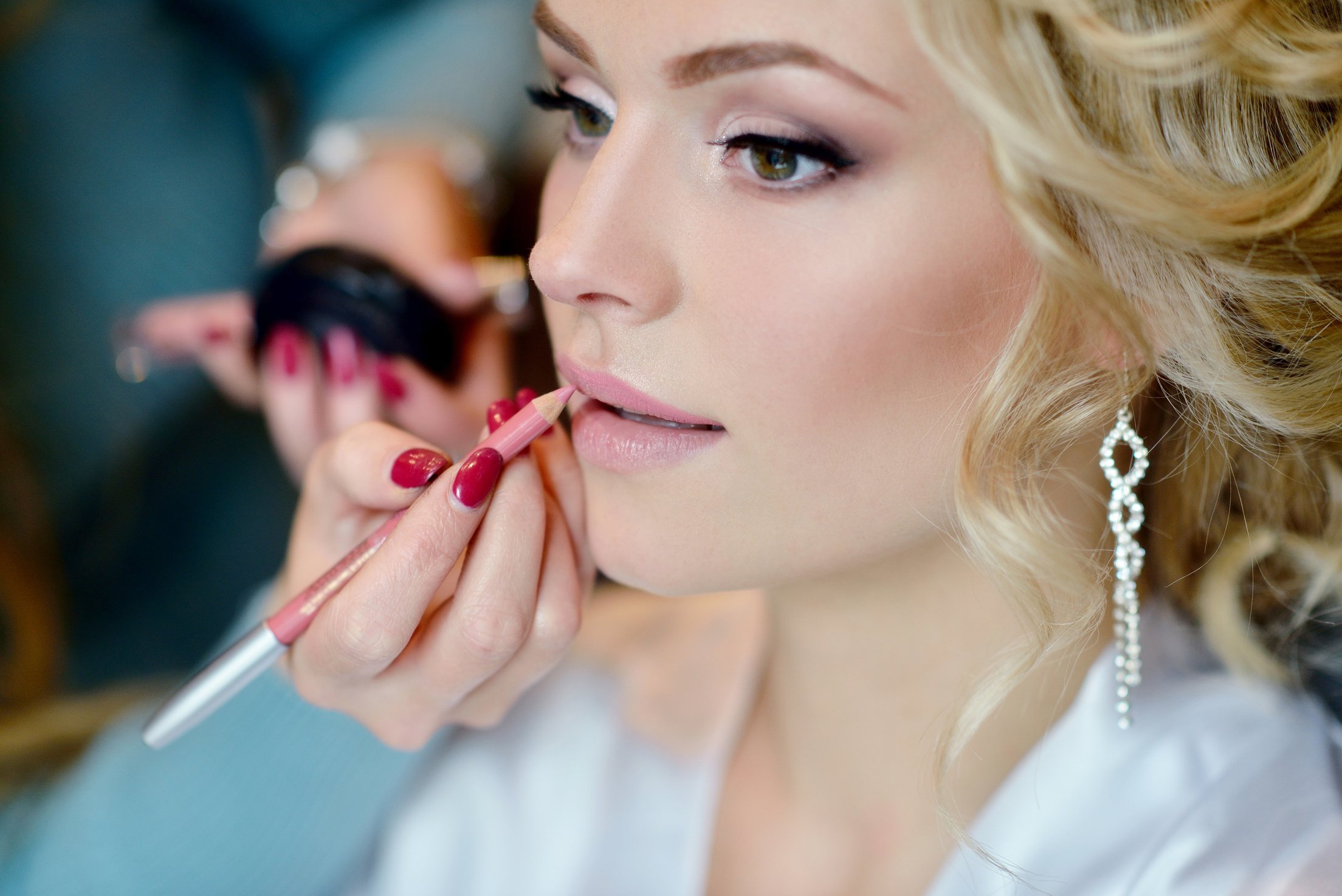 Wedding makeup artist making a make up for bride